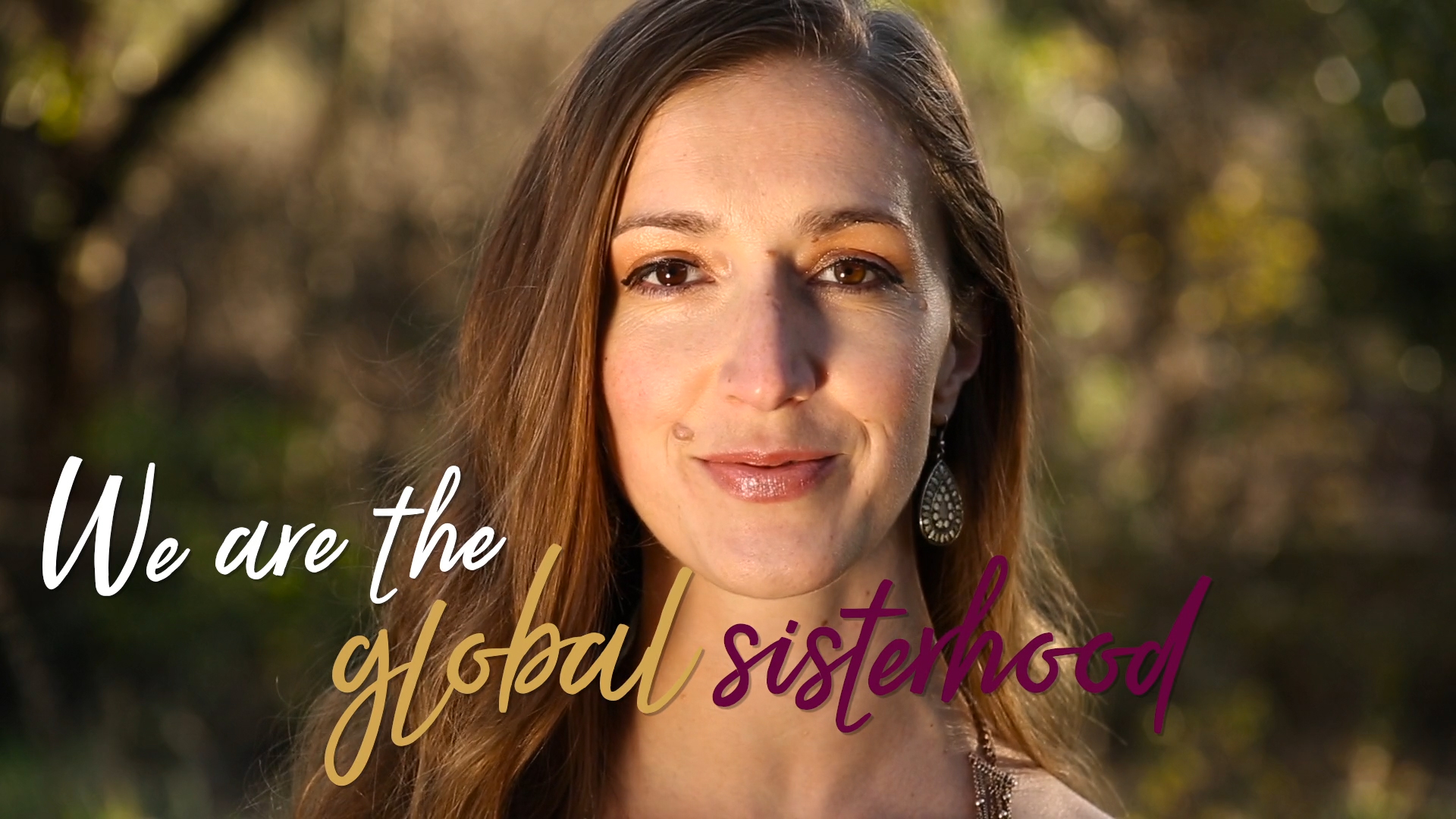 beautiful woman appears in the Global Sisterhood Pledge video with text on screen that reads: We are the global sisterhood