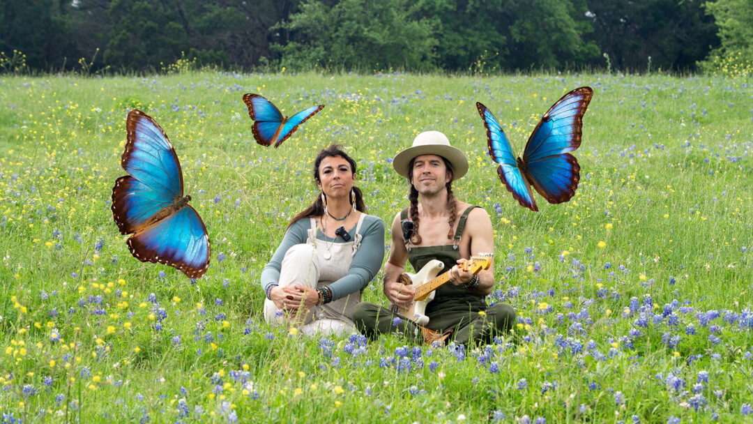 Austin video production service team filming on location — Arise Media Studio marketing videography and photography with blue morph butterflies flying mystically around people in a field of wildflowers